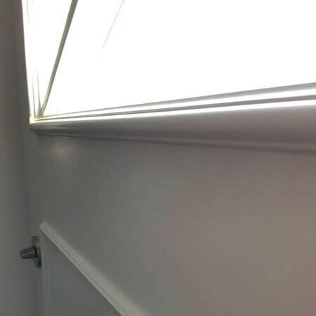 Ein Teil einer Haustür im Landhausstil mit einem Fenster. Tageslicht kommt durch das Fenster