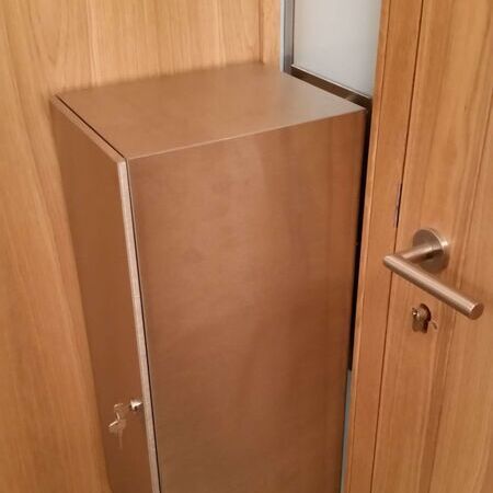 Nahaufnahme eines Edelstahlbriefkastenschlitzes in einer Holz-Eingangstür